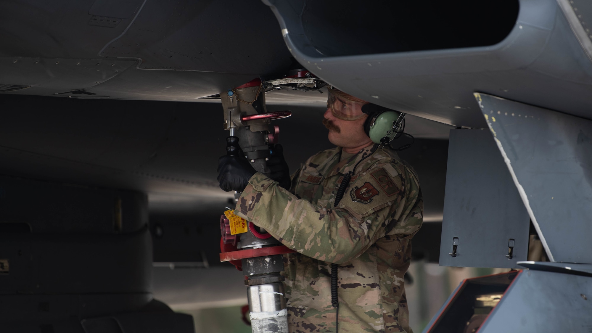 U.S. Air Force Tech. Sgt. Kyle Kudsen, 435th Contingency Response Squadron non-commissioned officer in charge of aircraft maintenance, performs a hot-pit refuel on a F-15E Strike Eagle at Royal Air Force Lakenheath, July 27, 2022. The training taking place gives the U.S. Air Force the ability to employ contingency response teams in support of combat assets in the European and African theaters. (U.S. Air Force photo by Airman Austin Salazar)