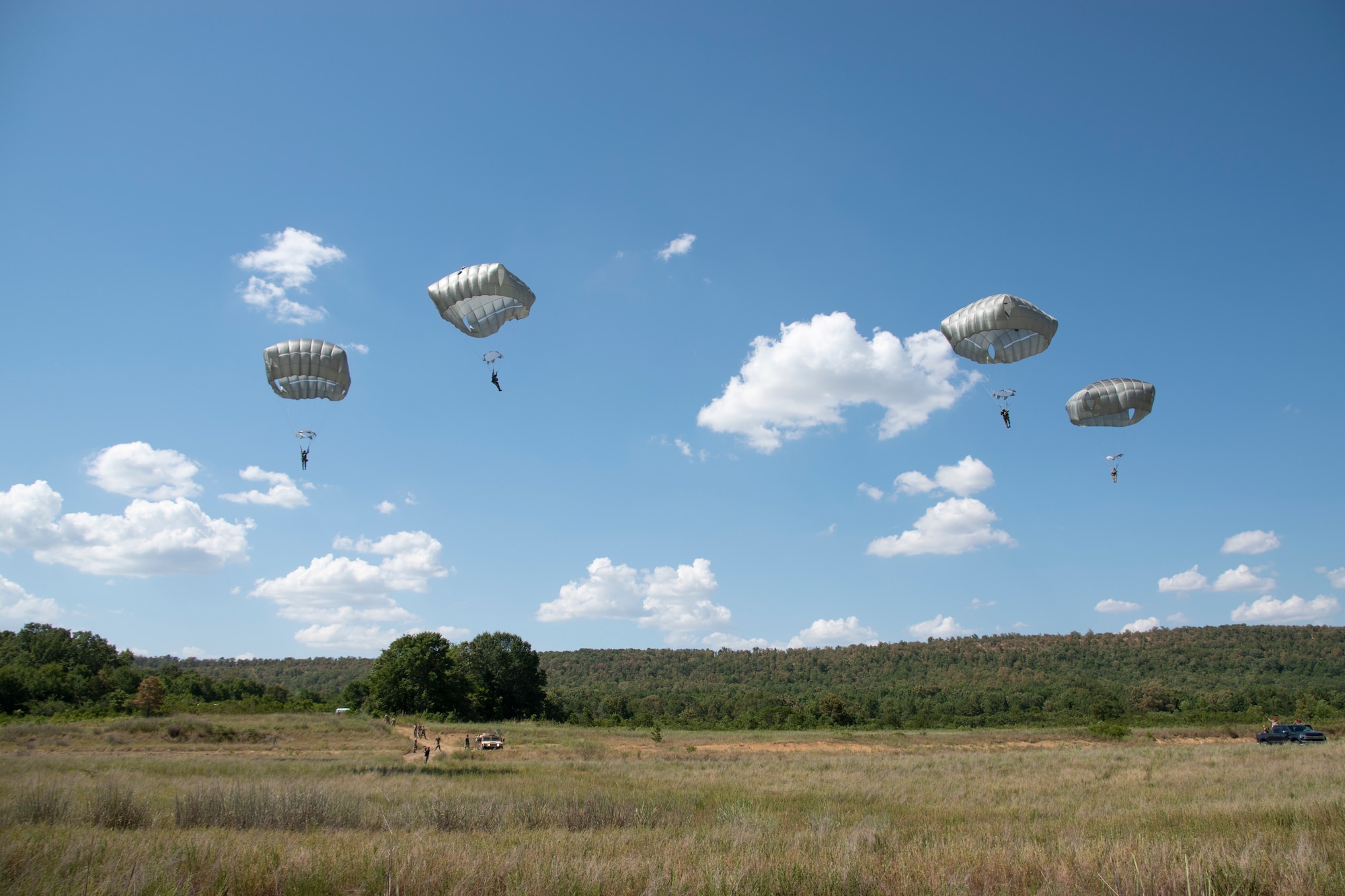 Soldiers from 2nd Battalion, 134th Infantry Regiment, 45th Infantry Brigade Combat Team, Nebraska Army National Guard, descend under parachute canopies during airborne operations training from a C-130 “Hercules” on Rattlesnake Drop Zone at Fort Chaffee, Arkansas, July 23, 2022. The 2nd Battalion is the newest unit to join the 45th IBCT, bringing with them airborne capabilities that the 45th has not had in more than 50 years. (Oklahoma National Guard photo by Staff Sgt. John Stoner)