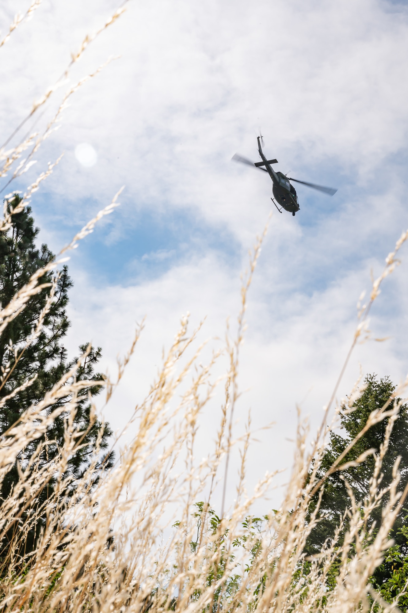 A UH-N1 Huey helicopter flies above the Sluice Boxes State Park trail during a search and rescue exercise Aug. 2, 2022, in Cascade County, Mont.