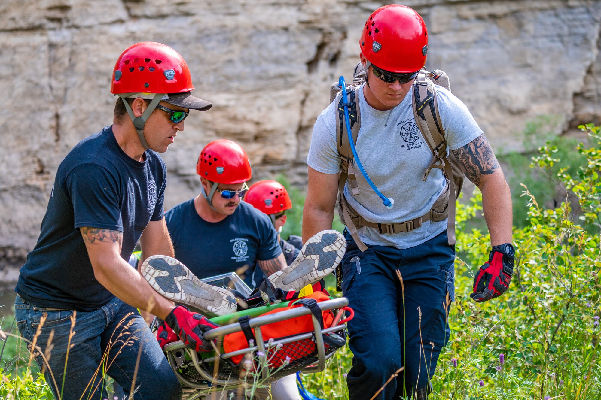 Members of the 341st Civil Engineer Fire Department transport Senior Airman Rocky Lane, 341st Civil Engineer Squadron heavy equipment operator, to the helicopter pick-up site during a search and rescue exercise August 3, 2022, in Sluice Boxes State Park.