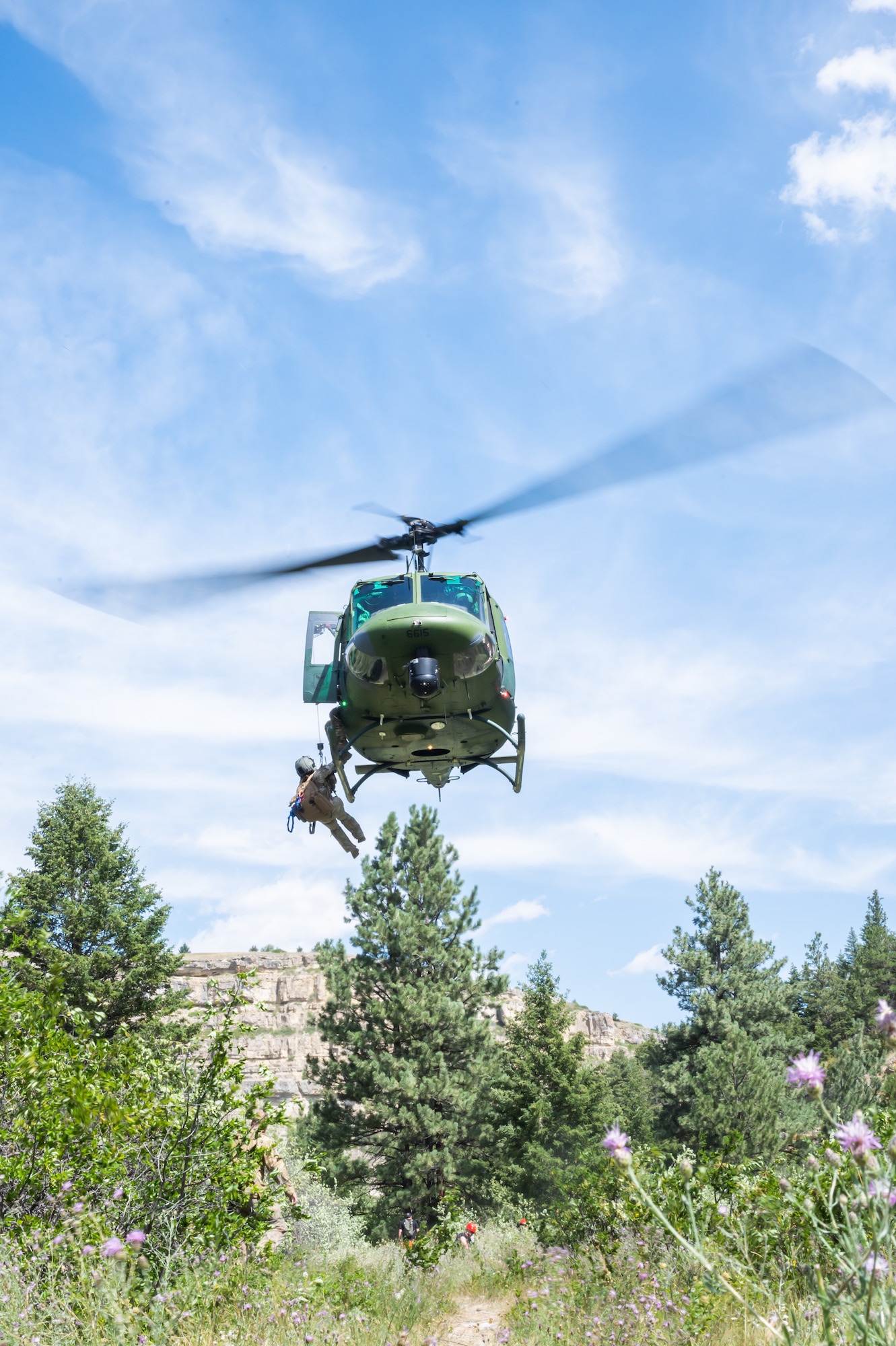 Maj. Joyanne Tesei, 341st Medical Group flight doctor, climbs into a UH-N1 Huey helicopter Aug. 2, 2022, above Sluice Boxes State Park, Mont.