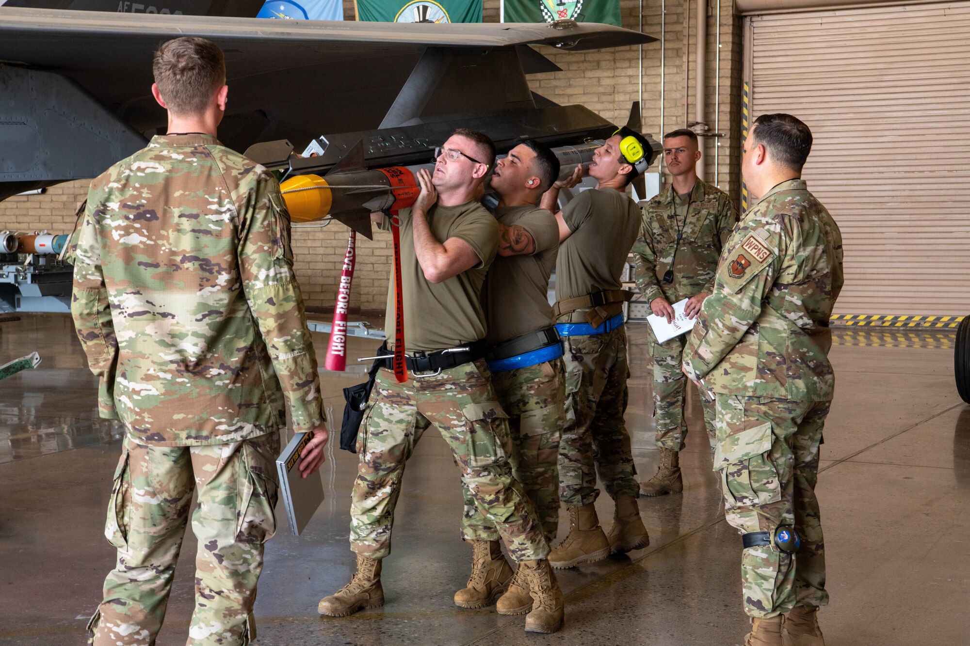 F-35 Lightning II maintainers load weapons onto an F-35 during a weapons load competition.