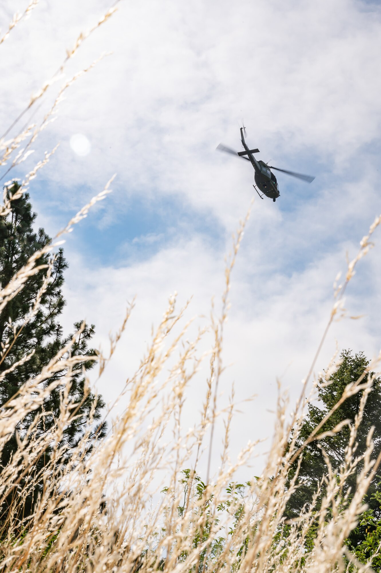 A UH-N1 Huey helicopter flies above the Sluice Boxes State Park trail during a search and rescue exercise Aug. 2, 2022, in Cascade County, Mont.