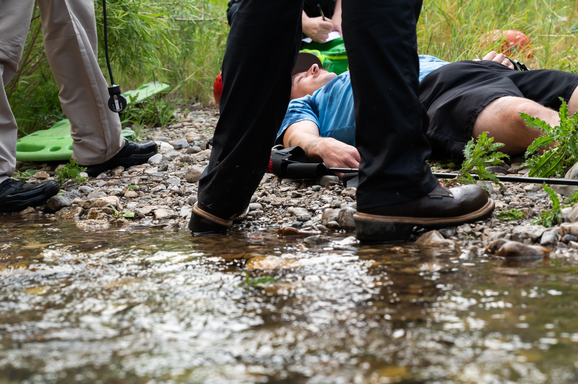 Senior Airman Rocky Lane, 341st Civil Engineer Squadron heavy equipment operator, lays on the ground next to Belt Creek to simulate sustaining an injury during a hike Aug. 2, 2022, in Sluice Boxes State Park, Mont.