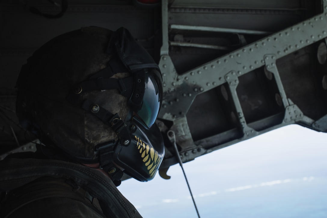 A U.S. Marine with Marine Heavy Helicopter Squadron (HMH) 466 moves to extract Marines from 3d Reconnaissance Battalion, 3d Marine Division executing an amphibious raid on Ukibaru Island, Okinawa, Japan, April 26, 2022. This specialized insertion and extraction training provided Marines with enhanced skills and confidence necessary for clandestine operations, ensuring they are prepared to execute a diverse set of waterborne reconnaissance and surveillance missions in order to maintain regional security in the Indo-Pacific. (United States Marine Corps photo by Cpl. Jackson Dukes)