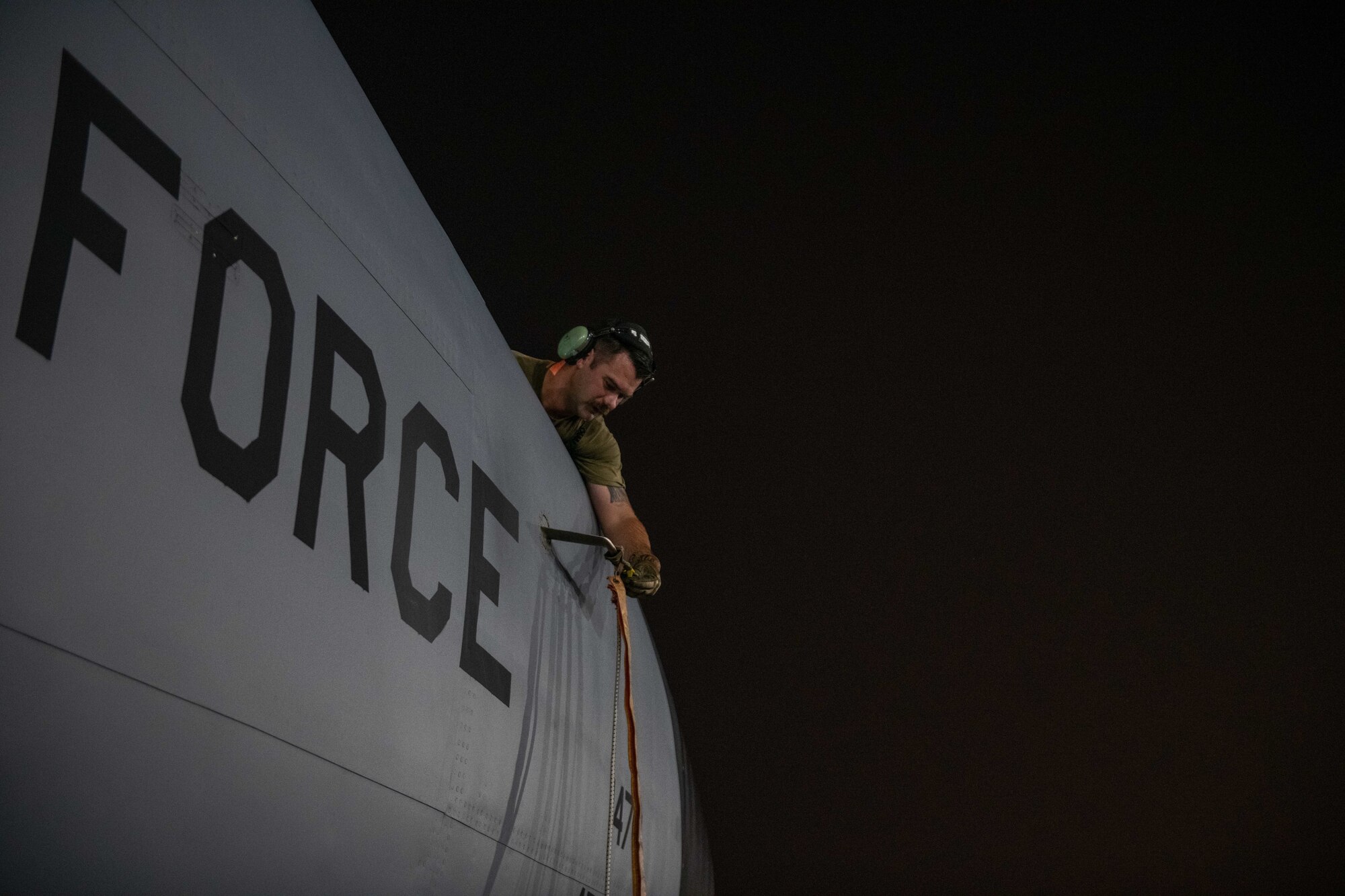 U.S. Air Force Staff Sgt. Nicholas Kinder, a KC-135 maintainer with the 379th Expeditionary Air Maintenance Squadron, secures a protective cover to a sensor on a KC-135 on Al Udeid Air Base, Qatar, Aug. 1, 2022. Aircraft maintainers operate constantly to support missions at any time of day. (U.S. Air National Guard photo by Airman 1st Class Constantine Bambakidis)