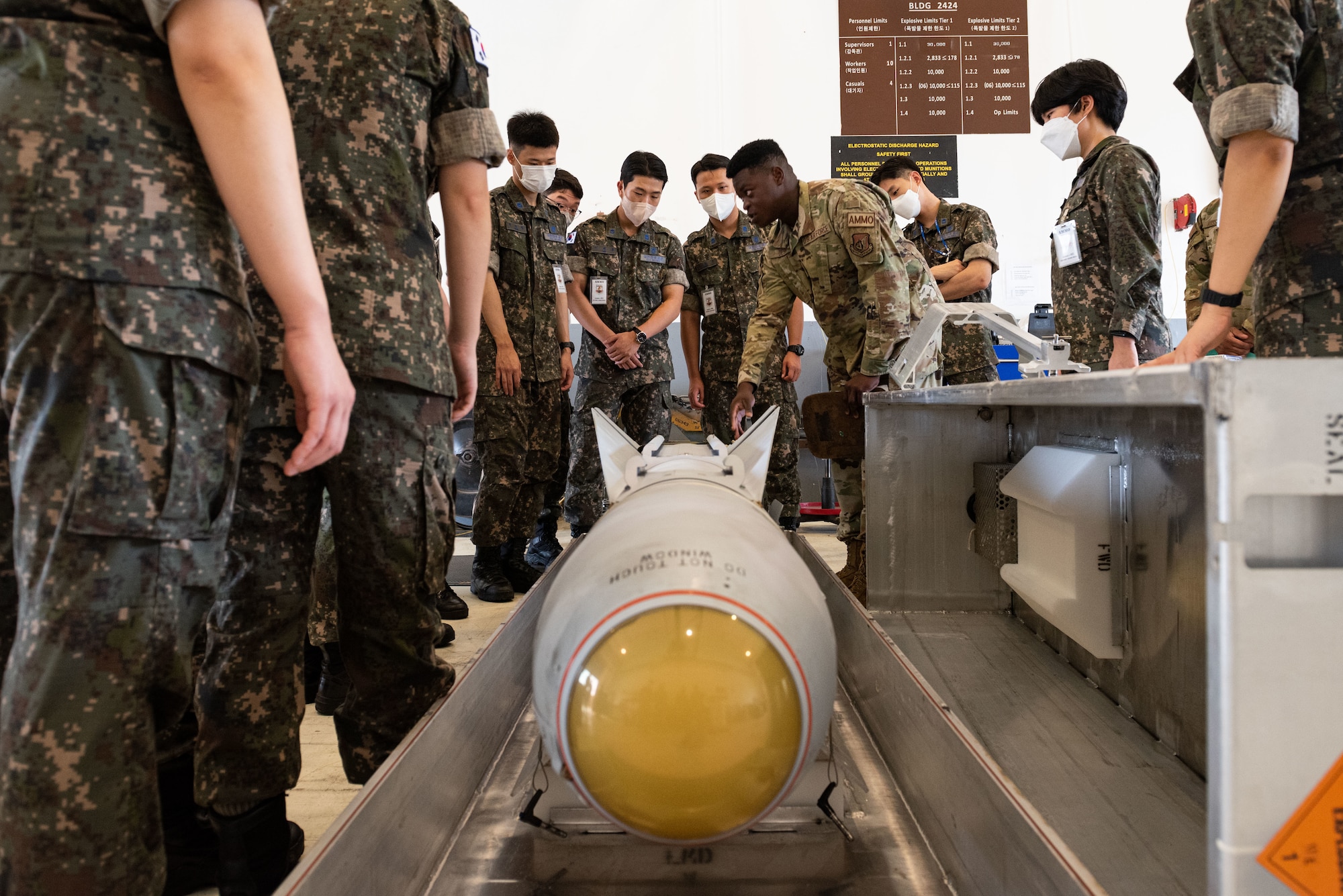 U.S. Air Force Airman 1st Class Yvener Desir, 51st Munitions Squadron precision-guided munition production crew member, explains the various components of an AGM-65 air-to-ground missile during an immersion tour for Republic of Korea Air Force translator officers at Osan Air Base, Republic of Korea, Aug. 2, 2022.