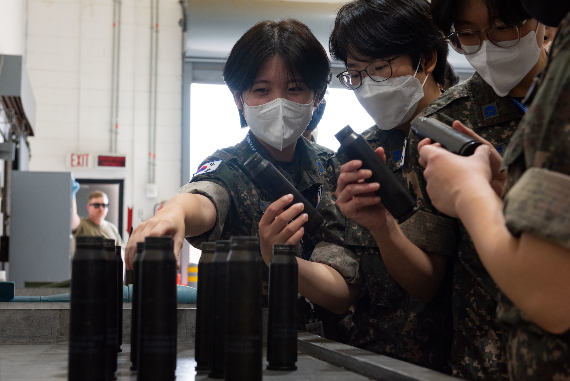 Republic of Korea Air Force translator officers, interact with A-10 Thunderbolt II 30mm casings during an immersion tour at Osan Air Base, Republic of Korea, Aug. 2, 2022.