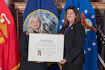 two women in business attire holding certificate