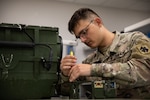 Spc. Robert Morris, a radio equipment repairer with Company B, 700th Brigade Support Battalion, 45th Infantry Brigade Combat Team, Oklahoma National Guard, works on a SINCGARS radio at the Sustainment Training Center on Camp Dodge near Johnston City, Iowa, July 18, 2022. Repairers assigned to the 700th BSB conducted technical repair training in a realistic, multi-echelon environment as part of their annual training.