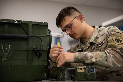 Spc. Robert Morris, a radio equipment repairer with Company B, 700th Brigade Support Battalion, 45th Infantry Brigade Combat Team, Oklahoma National Guard, works on a SINCGARS radio at the Sustainment Training Center on Camp Dodge near Johnston City, Iowa, July 18, 2022. Repairers assigned to the 700th BSB conducted technical repair training in a realistic, multi-echelon environment as part of their annual training.