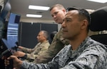 Colombian air force Brig. Gen. Pedro Arnulfo Sánchez Suárez (right), Joint Special Operations Command deputy commander, conducts an exercise on a Vigilant Spirit simulator during a visit to the 558th Flying Training Squadron at Joint Base San Antonio-Randolph, Texas, July 27, 2022. The Vigilant Spirit simulator is designed to be immersive and realistic for remotely piloted aircraft operators.