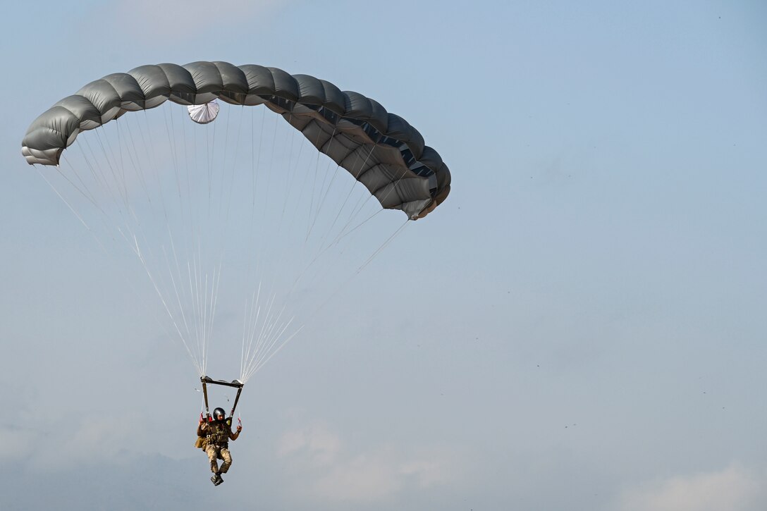 An airman parachutes to the ground.