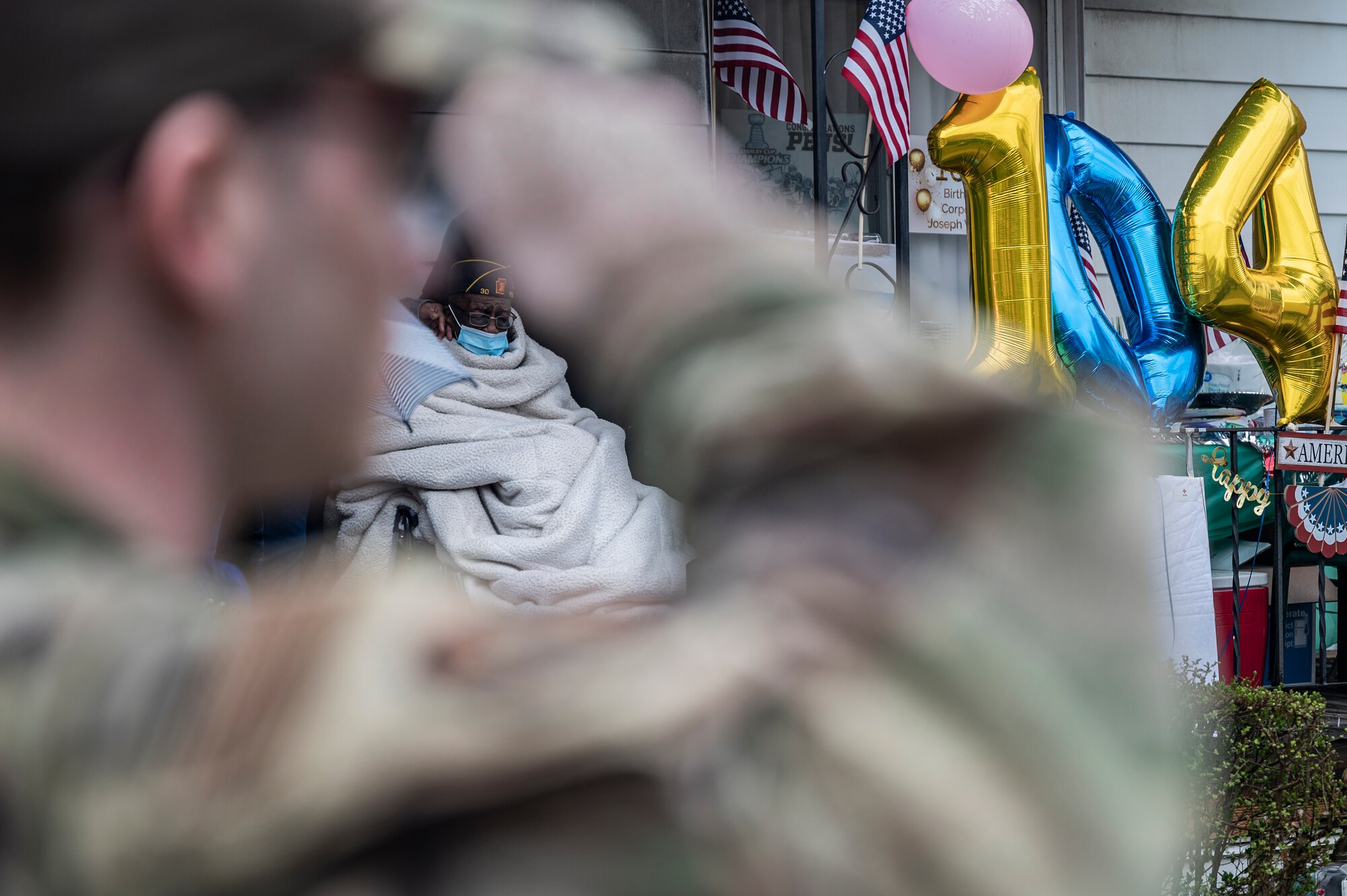 An Airman assigned to the 911th Airlift Wing salutes during the playing of the National Anthem in front of the house of Joseph Wilbon, a World War II veteran, in Pittsburgh, Pennsylvania, April 11, 2022