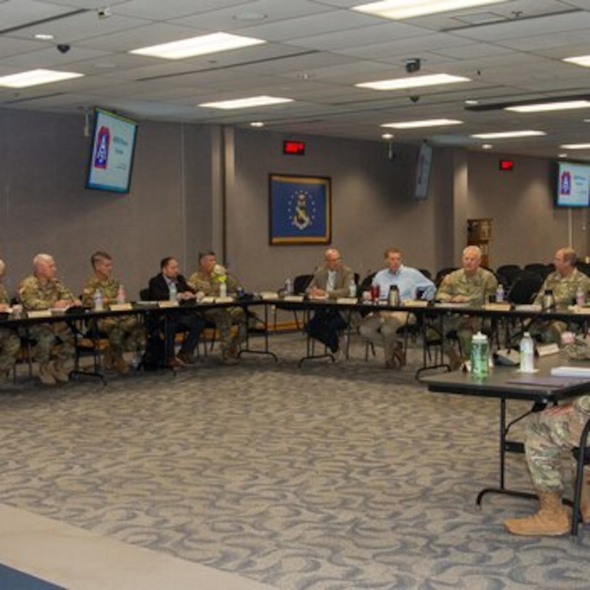 Military and civilian members sit at a table.