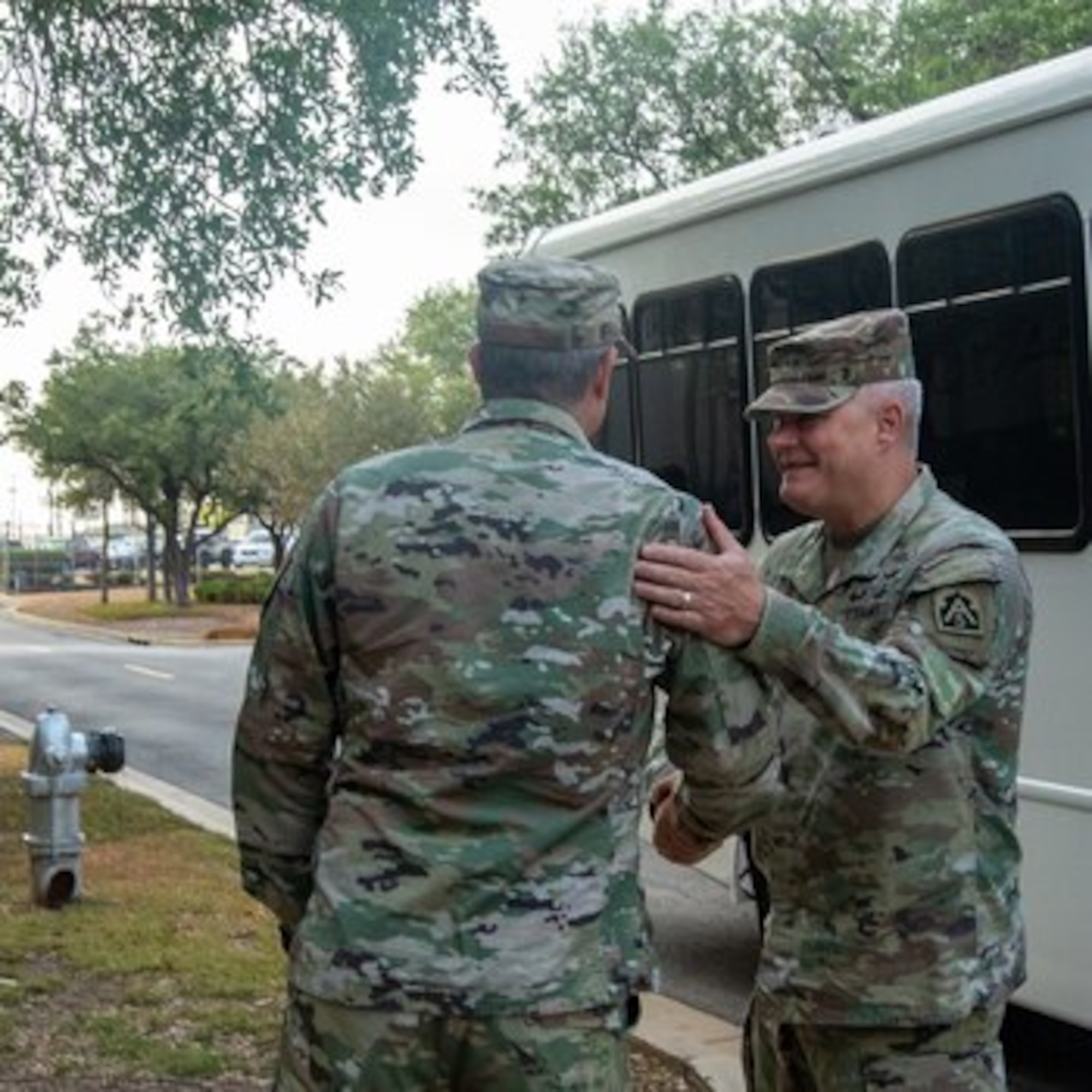 Two leaders in uniform shake hands.