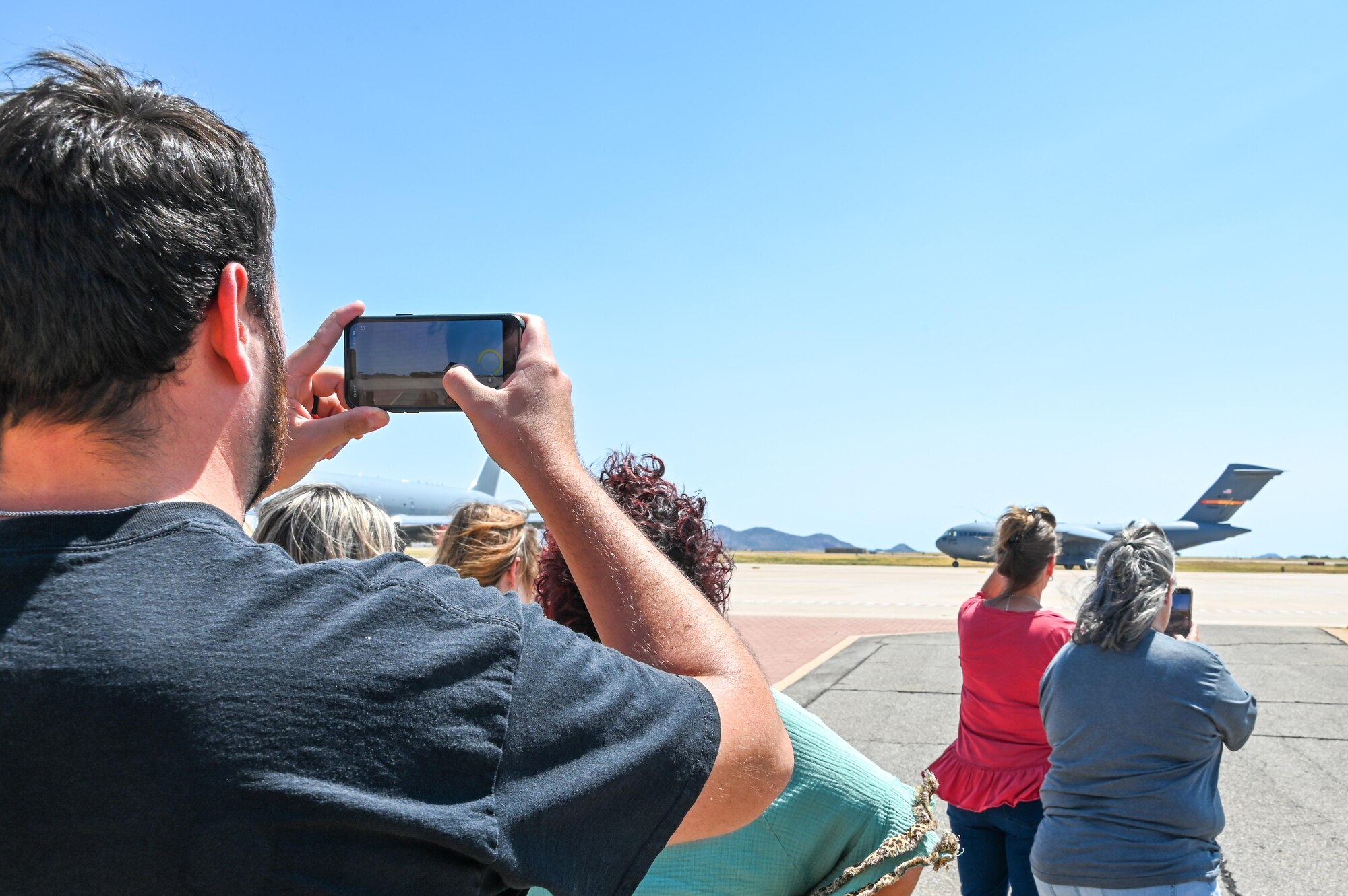 Local teachers take photos of a C-17 Globemaster III at Altus Air Force Base, Oklahoma, Aug. 2, 2022. The teachers ended their tour with an opportunity to see the flightline and take photos of aircraft. (U.S. Air Force photo Senior Airman Kayla Christenson)