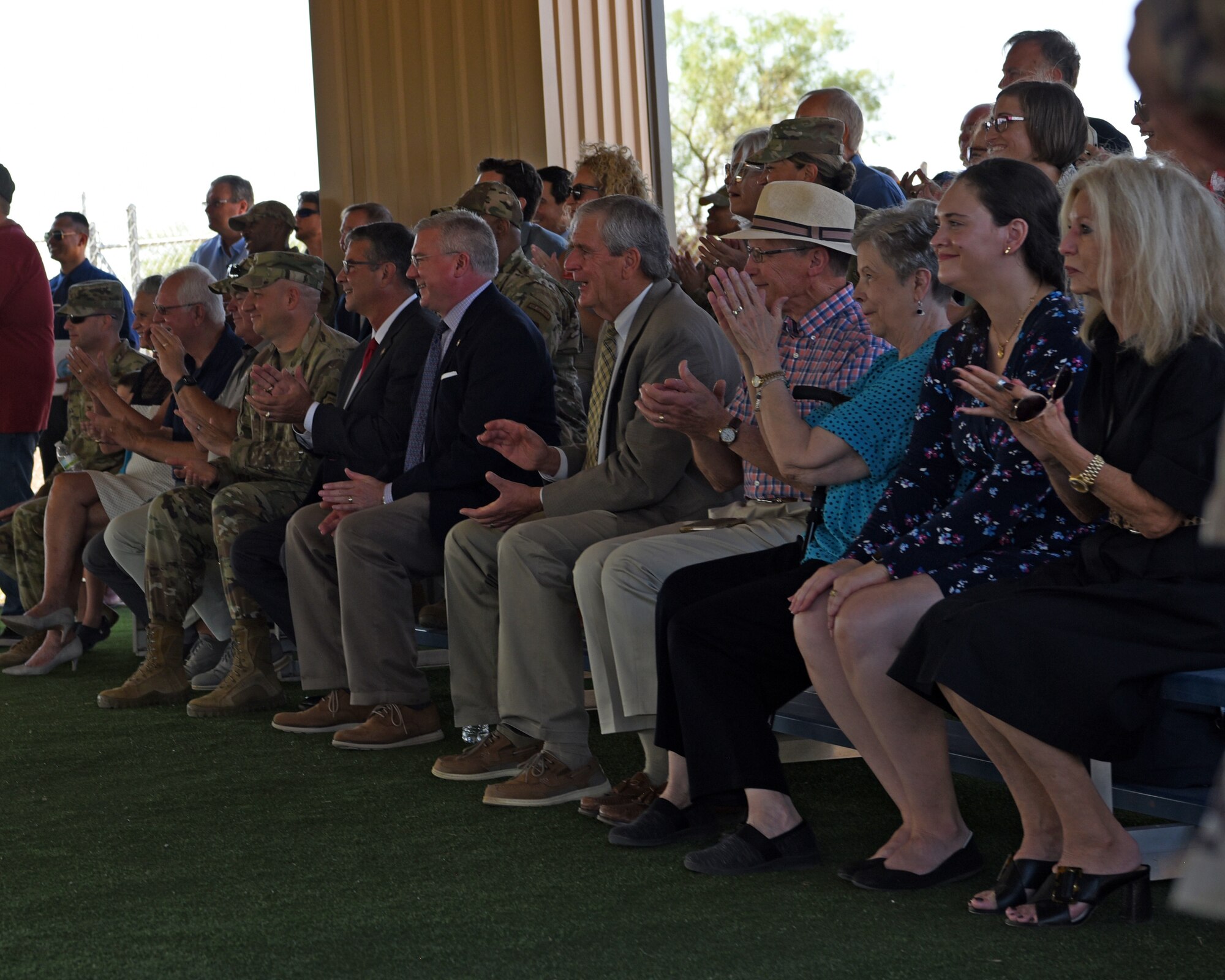 U.S. Air Force senior leaders from Goodfellow Air Force Base and civic leaders from the City of San Angelo and across Texas, applaud a military working dog demonstration at Goodfellow Air Force Base, Texas, Aug. 3, 2022. The attendees rallied together in celebration of a $5.2 million infrastructure upgrade from a Defense Economic Adjustment Assistance Grant awarded by the state of Texas, through which the MWD training pad was built. (U.S. Air Force photo by Senior Airman Abbey Rieves)
