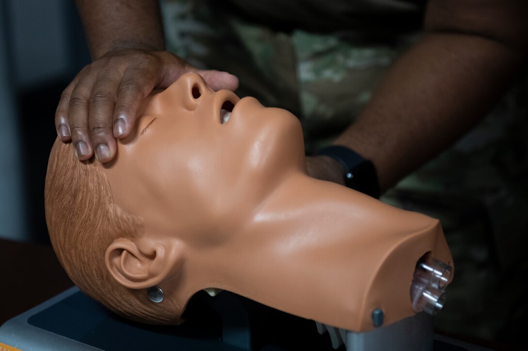 U.S. Air Force Senior Airman Bertrand Vicks, 325th Fighter Wing safety technician demonstrates the proper technique to open an airway at Tyndall Air Force Base, Florida, July 21, 2022. After treating massive bleeds, ensuring members have an unobstructed airway is the next step when performing Tactical Combat Casualty Care. (U.S. Air Force photo by Staff Sgt. Cheyenne Lewis)