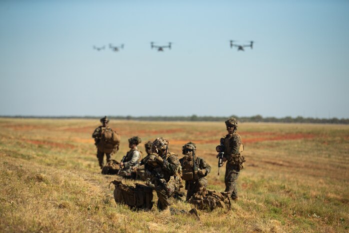 U.S. Marines with 3d Battalion, 7th Marine Regiment, Ground Combat Element, Marine Rotational Force-Darwin 22, establish defensive positions as MV-22 Ospreys approach for landing during an airfield seizure event as part of exercise Koolendong 22 at Royal Australian Air Force Base Curtin, WA, Australia, July 18, 2022. Exercise Koolendong 22 is a combined and joint force exercise focused on expeditionary advanced base operations conducted by U.S. Marines, U.S. Soldiers, U.S. Airmen, and Australian Defence Force personnel.