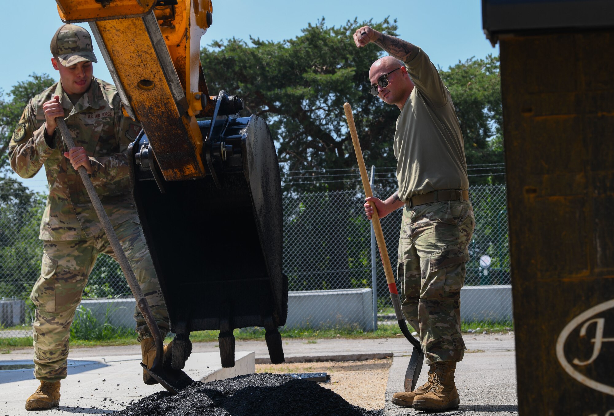 Senior Airman Parker Roberts, 31st Civil Engineer Squadron pavements and heavy equipment journeyman, right, and Senior Airman Jacob Bates, 31st CES pavements and heavy equipment journeyman, prepares asphalt for paving at Aviano Air Base, Italy, June 30, 2022. As members of the 31st CES’s “Dirt Boyz” section, Roberts and Parker are responsible for any CE project that involves construction and repair on runways, roads, sidewalks and more. (U.S. Air Force photo by Airman 1st Class Thomas Calopedis)