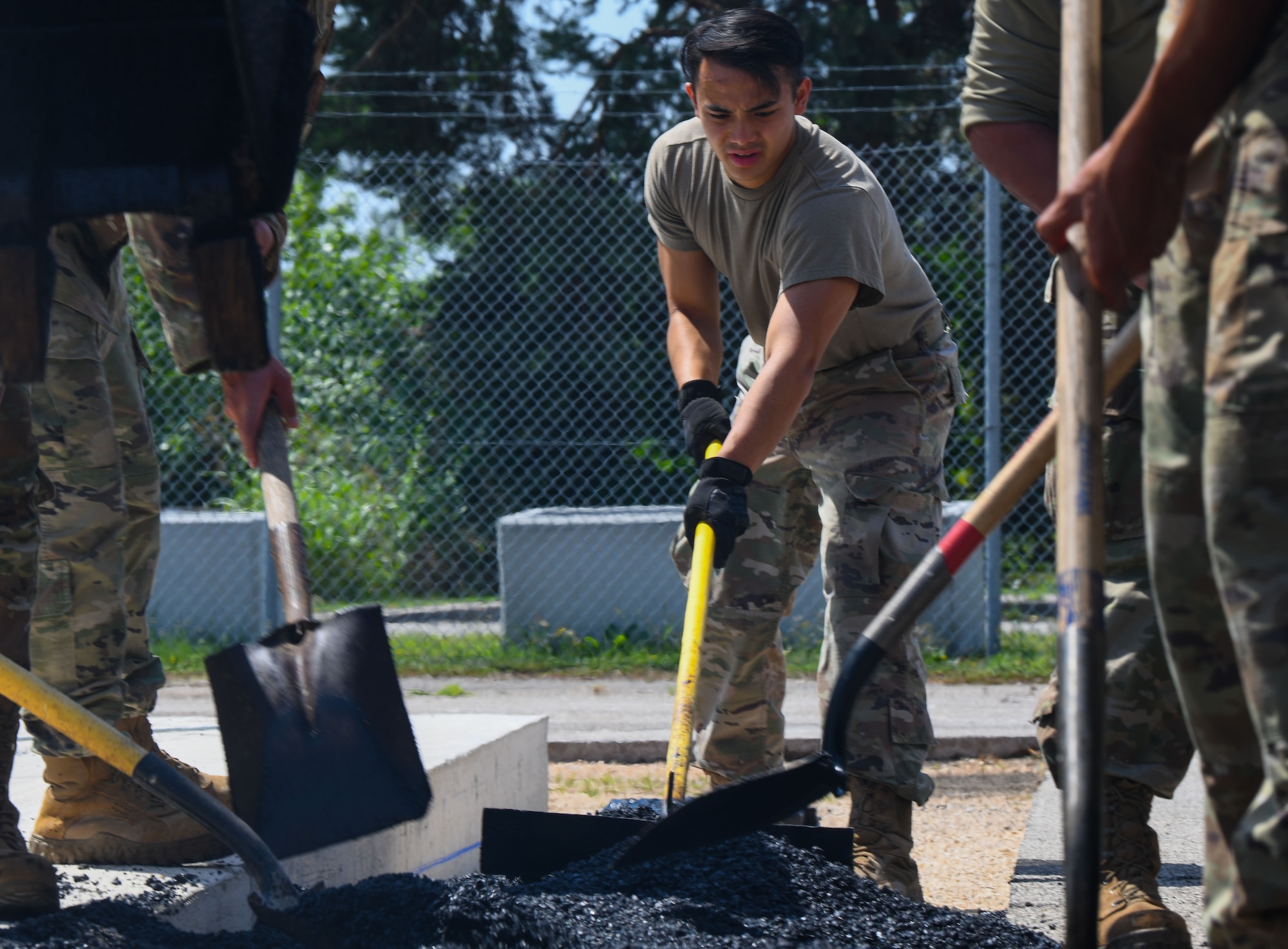 Members of the 31st Civil Engineer Squadron “Dirt Boyz” section spread asphalt for paving at Aviano Air Base, Italy, June 30, 2022. Dirt Boyz are responsible for any CE project that involves construction and repair on runways, roads, sidewalks and more. (U.S. Air Force photo by Airman 1st Class Thomas Calopedis)