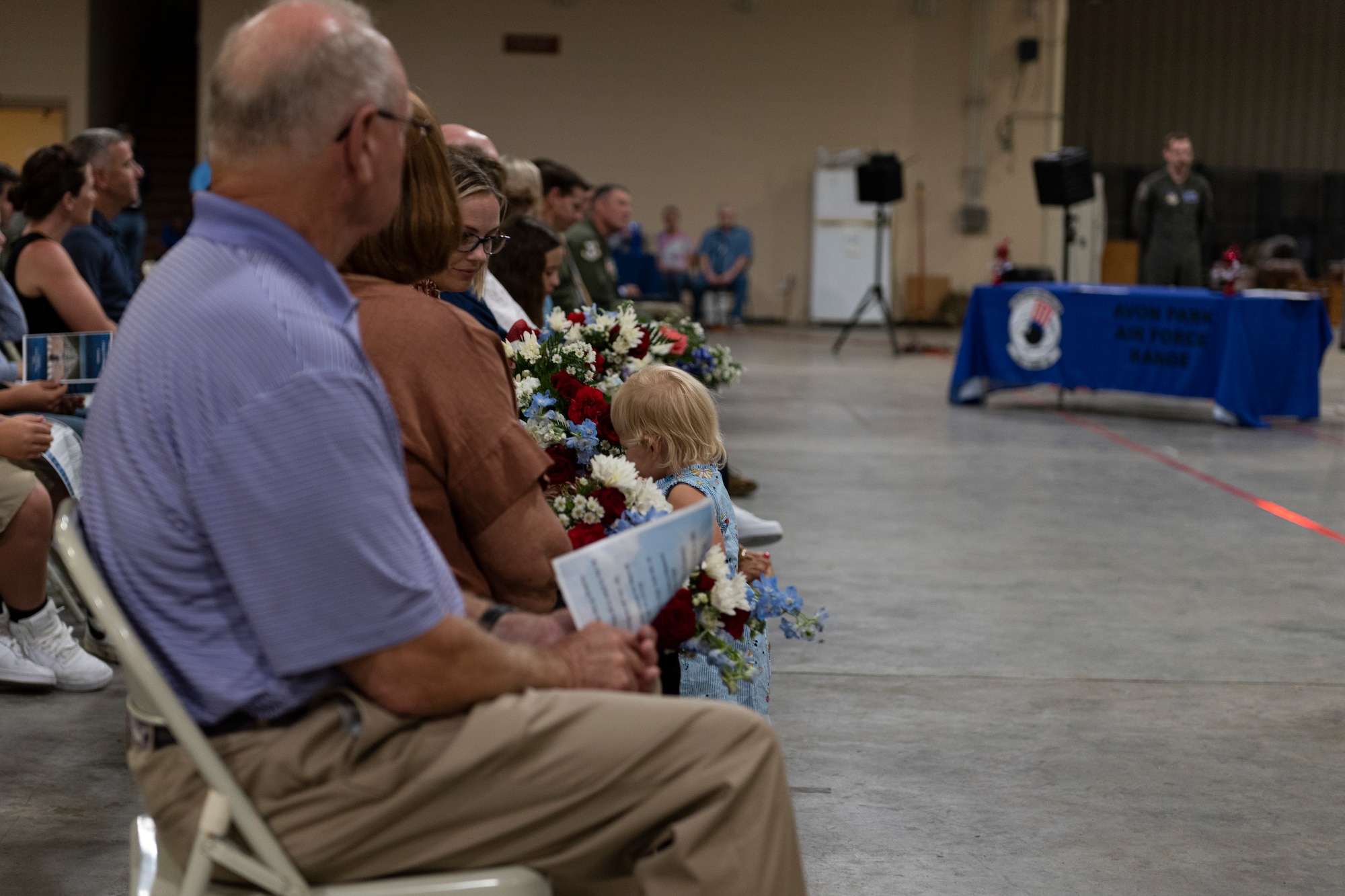 Photo of an Airman's daughter smelling flowers