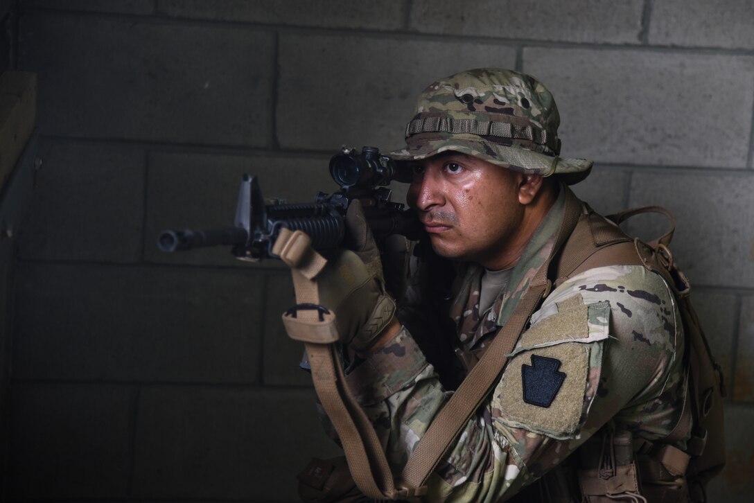 U.S. Army National Guard Soldiers conquer the culminating training event on the way to earning the 11B Infantryman military occupational speciality July 27, 2022, at Fort Picket, Virginia. The Soldiers repeatedly worked their way through an urban training site using dry fire before donning protective gear and utilizing simulation rounds against opposing forces as they secured the site. The exercise was part of the three-week 11B Infantry Transition Course, taught by cadre assigned to the 183rd Regiment, Regional Training Institute. The course brought together more than 20 Soldiers from across the nation to learn basic infantry skills at the junior Soldier and noncommissioned officer level. (U.S. Army National Guard photo by Sgt. 1st Class Terra C. Gatti)