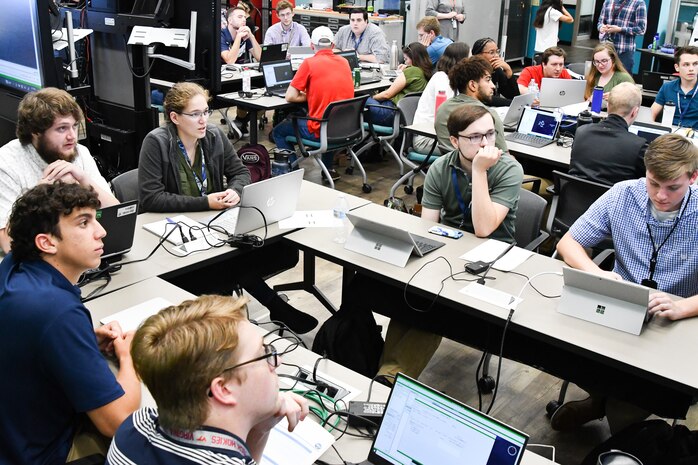 IMAGE: The Weapons Control and Integration Department team of interns watch the big screen as their digital convoy of World War II era U.S. Navy ships battles with enemy U-boats during the Innovation Lab’s Wargaming Hackathon on July 12. After three rounds, the team earned first overall in the competition that featured summer interns from all seven of Naval Surface Warfare Center Dahlgren Division technical departments.