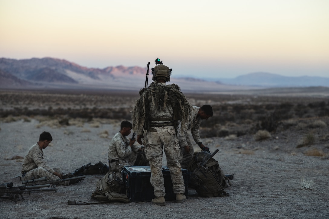 U.S. Marine scout snipers with Weapons Company, 3rd Battalion, 4th Marine Regiment, finish preparing for the non-live fire portion of the Ground Reconnaissance Course at Marine Corps Air Ground Combat Center, Twentynine Palms, California, May 16, 2022. During the course, Marines were tasked with patrolling and observing live role players’ positions and movements undetected. (U.S. Marine Corps photo by Lance Cpl. Andrew R. Bray)