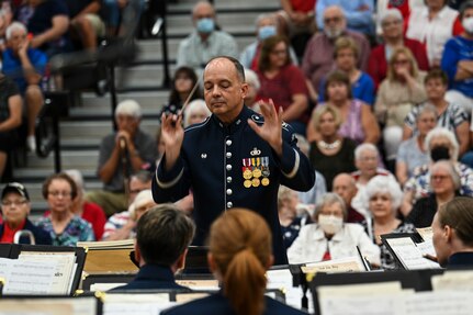 U.S. Air Force Col. Don Schofield, commander and conductor of The United States Air Force Band conducts a concert at Paris, Ind., July 3, 2022. The Concert Band is one of six musical ensembles that form The U.S. Air Force Band and is the official symphonic wind ensemble of the U.S. Air Force. (U.S. Air Force photo by Airman Bill Guilliam)