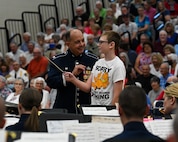 U.S. Air Force Col. Don Schofield, commander and conductor of The United States Air Force Band, teaches a local student how to conduct a band at Paris, Ind., July 3, 2022. The Concert Band performs a wide variety of music ranging from classical transcriptions and original works to solo features, light classics, popular favorites, and patriotic selections. (U.S. Air Force photo by Airman Bill Guilliam)