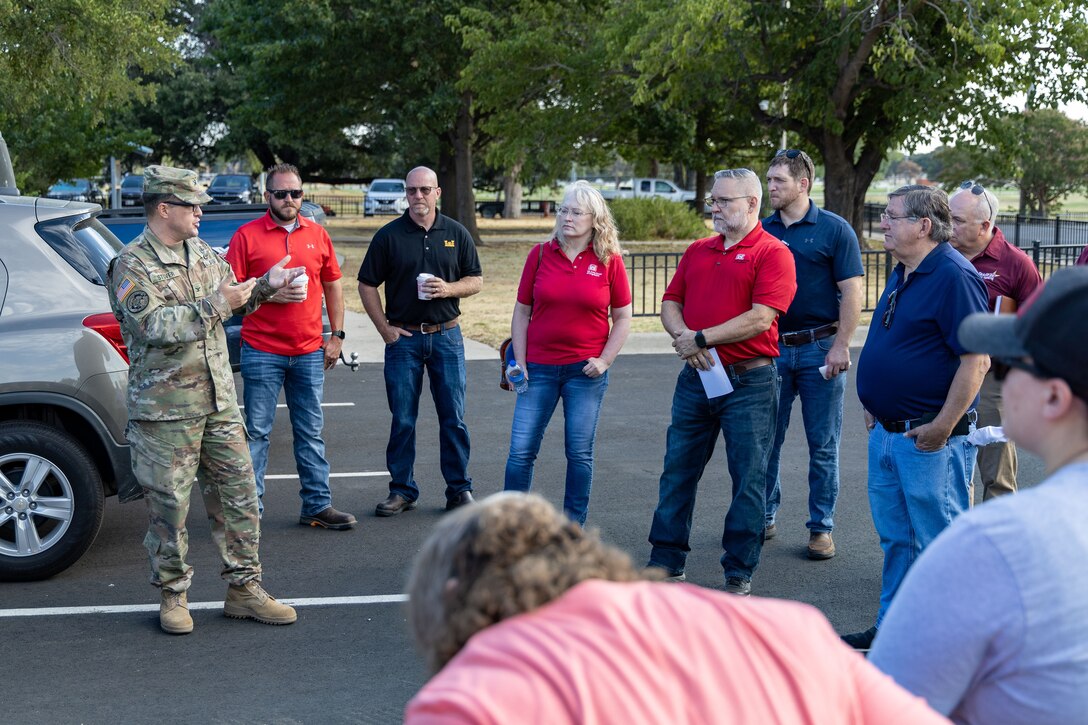 a group of people standing in a parking lot talking
