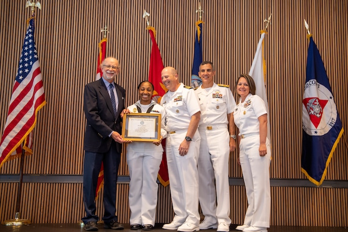 Master-At-Arms 2nd Class Breanna Byrd, assigned to Naval Station Everett, poses for a photo with Rear Adm. Carlos Sardiello, commander, Carrier Strike Group 1, and other command members during the Seattle Navy League Sea Services Awards Luncheon at Fleet Week, Aug. 4, 2022. Fleet Week Seattle is a time-honored celebration of the sea services and provides an opportunity for the citizens of Washington to meet Sailors, Marines and Coast Guardsmen, as well as witness firsthand the latest capabilities of today's maritime services. (U.S. Navy photo by Mass Communication Specialist 2nd Class Victoria Galbraith)