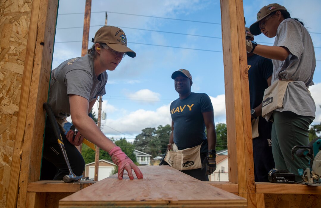 Lt.j.g. Caitlyn Bezecny, attached to Ticonderoga-class guided missile cruiser USS Lake Champlain (CG 57), instructs Sailors on measuring and cutting wood at a Habitat for Humanity community relations event during Fleet Week Seattle, Aug. 4, 2022. Fleet Week Seattle is a time-honored celebration of the sea services and provides an opportunity for the citizens of Washington to meet Sailors, Marines and Coast Guardsmen, as well as witness firsthand the latest capabilities of today's maritime services. (U.S. Navy Photo by Mass Communication Specialist 2nd Class Ethan J. Soto)
