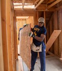 Midshipman Tyrell Walker, attached to Ticonderoga-class guided missile cruiser USS Lake Champlain (CG 57), moves a wood panel at a Habitat for Humanity community relations event during Fleet Week Seattle, Aug. 4, 2022. Fleet Week Seattle is a time-honored celebration of the sea services and provides an opportunity for the citizens of Washington to meet Sailors, Marines and Coast Guardsmen, as well as witness firsthand the latest capabilities of today's maritime services. (U.S. Navy Photo by Mass Communication Specialist 2nd Class Ethan J. Soto)