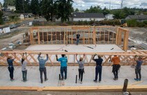 Sailors from USS Lake Champlain (CG 57) raise a wall at a Habitat for Humanity event during Fleet Week Seattle.