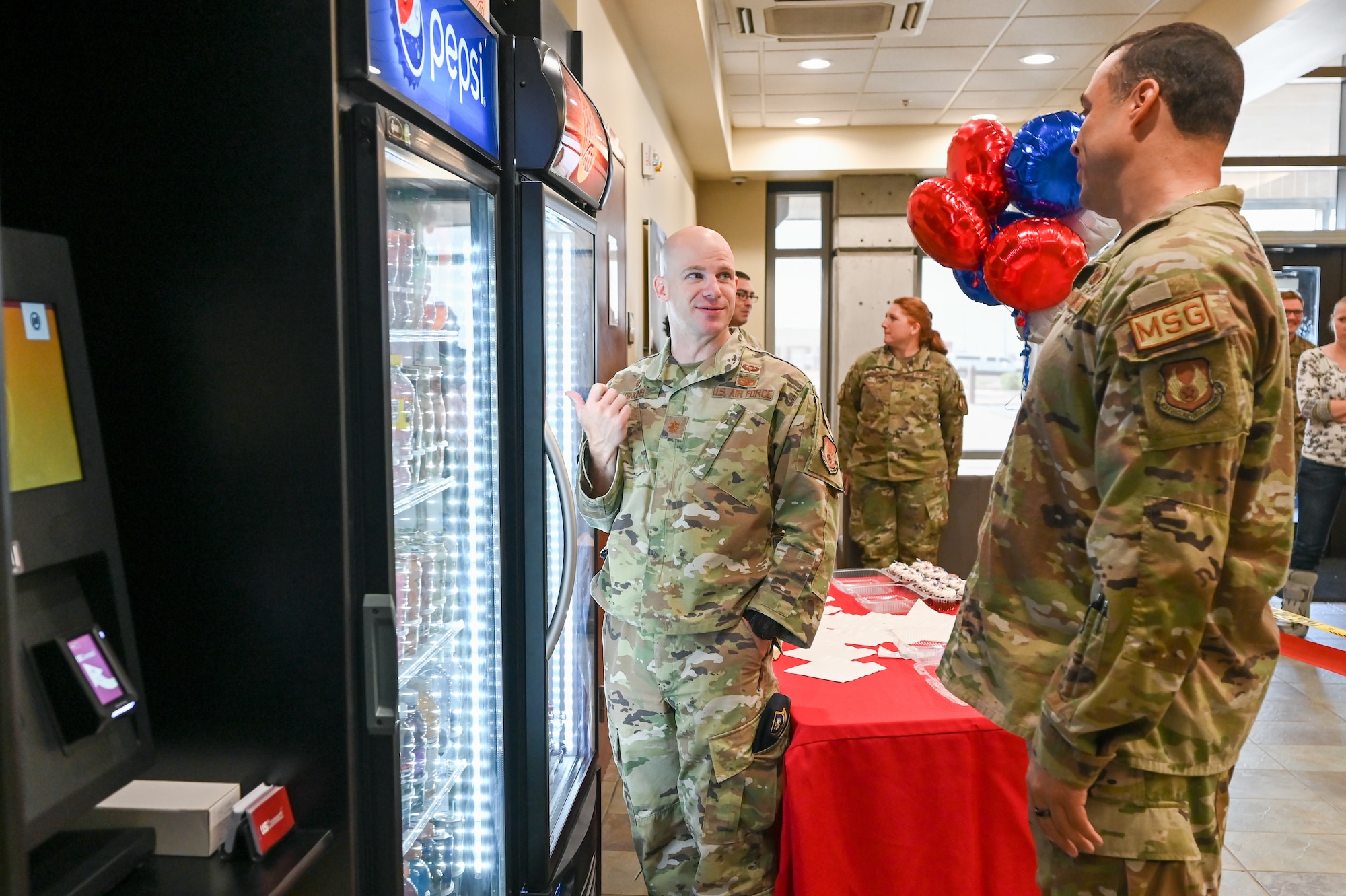 Maj. Paul Dinkins, 75th Security Forces Squadron commander, and Col. Khalim Taha, 75th Mission Support Group commander, look over the items in the new micro marke