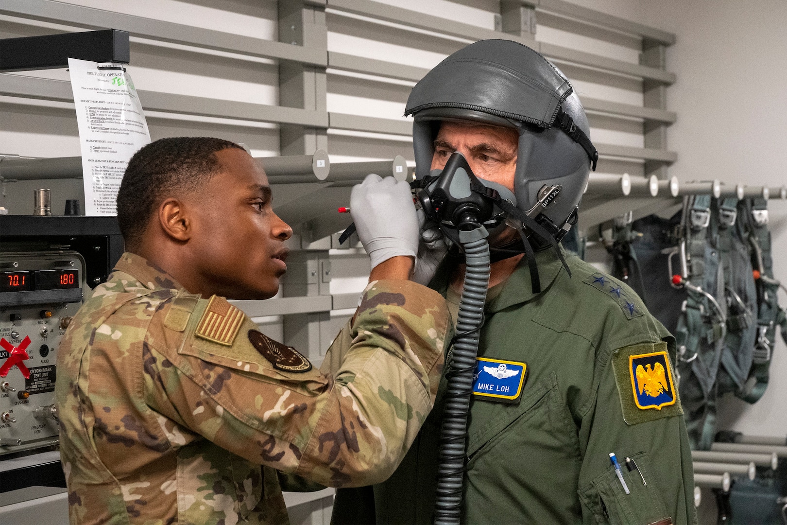 U.S. Air Force Senior Airman Anthony Ratliff, aircrew flight equipment technician with 509th Operations Support Squadron, checks Air National Guard Director Lt. Gen. Michael Loh's oxygen mask for leaks during his visit to Whiteman Air Force Base, Missouri, May 13, 2022. Loh visited the Missouri Air National Guard's 131st Bomb Wing to learn about the total force B-2 Spirit stealth bomber mission. (U.S. Air National Guard photo by Master Sgt. John E. Hillier)