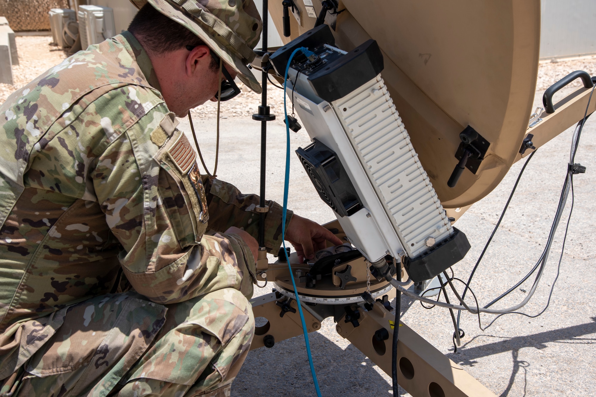 Airman 1st Class Nathan Ammons operates a Communications Fly Away Kit at an undisclosed location, July 20, 2022. The CFK enables the 332d Air Expeditionary Squadron to operate in remote locations by establishing secure communications via satellite. (U.S. Air Force photo by: Tech. Sgt. Jim Bentley)