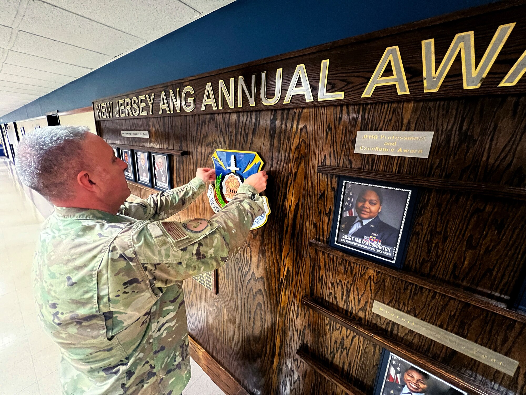 U.S. Air Force Senior Master Sgt. David Fortin, 108th Wing Fabrication Flight Supervisor, hangs a custom-made New Jersey Joint Force Headquarters Shield on the awards wall in Joint Force Headquarters on Joint Base McGuire-Dix-Lakehurst, New Jersey, June 15, 2022.