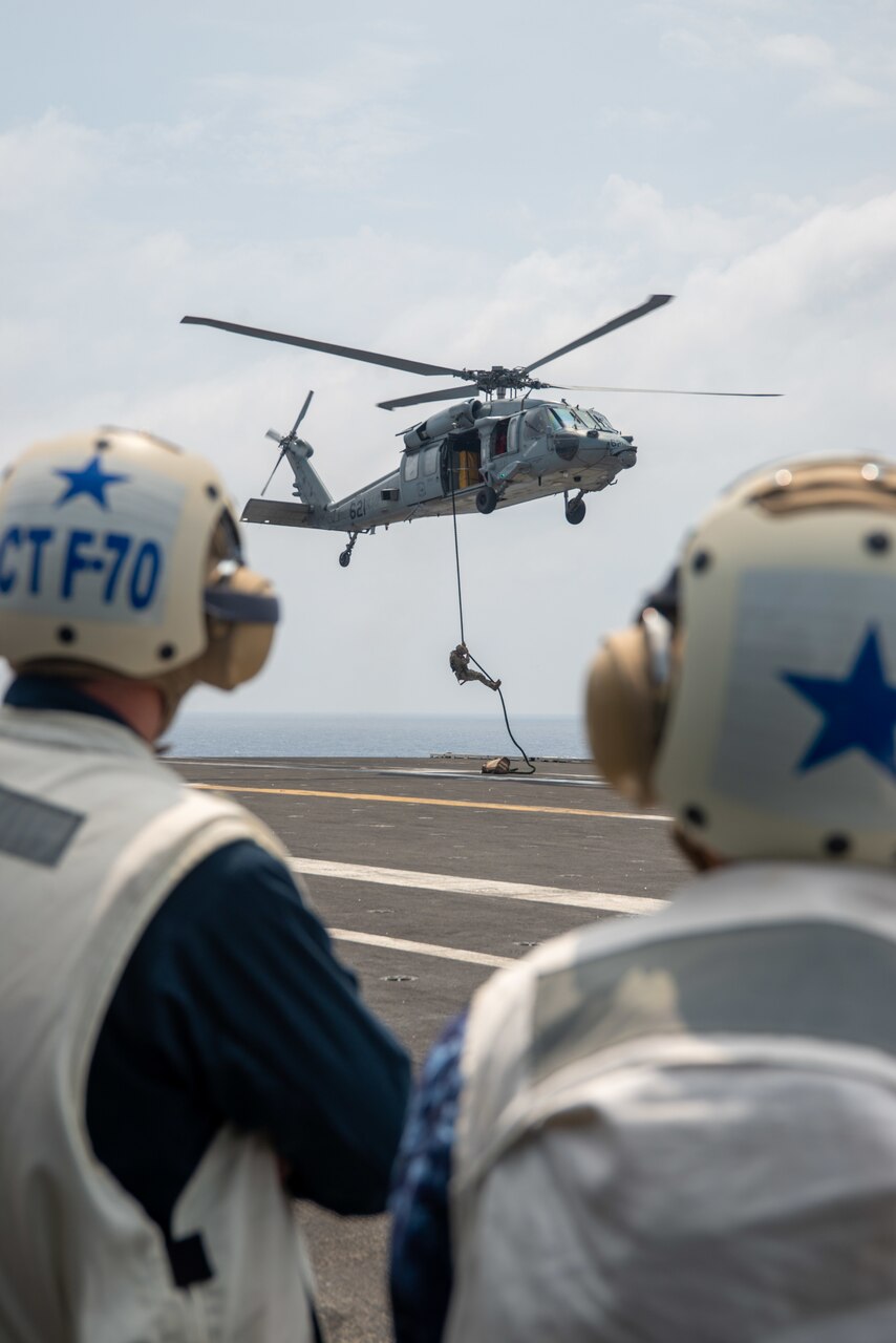 PHILIPPINE SEA (Aug. 5, 2022) Rear Adm. Michael Donnelly, left, Commander, Task Force 70, and Vice Adm. Fukuda, Commander, Fleet Escort Force, Japan Maritime Self-Defense Force observe Sailors conducting fast-rope exercises on the flight deck of the U.S. Navy’s only forward-deployed aircraft carrier USS Ronald Reagan (CVN 76) in the Philippine Sea, Aug. 5. Fukuda and his staff, as well as members of the Japan Ministry of Defense and media personnel, observed flight operations and toured various parts of the ship during their time aboard. Ronald Reagan, the flagship of Carrier Strike Group 5, provides a combat-ready force that protects and defends the United States, and supports alliances, partnerships and collective maritime interests in the Indo-Pacific region. (U.S. Navy photo by Mass Communication Specialist 3rd Class Gray Gibson)