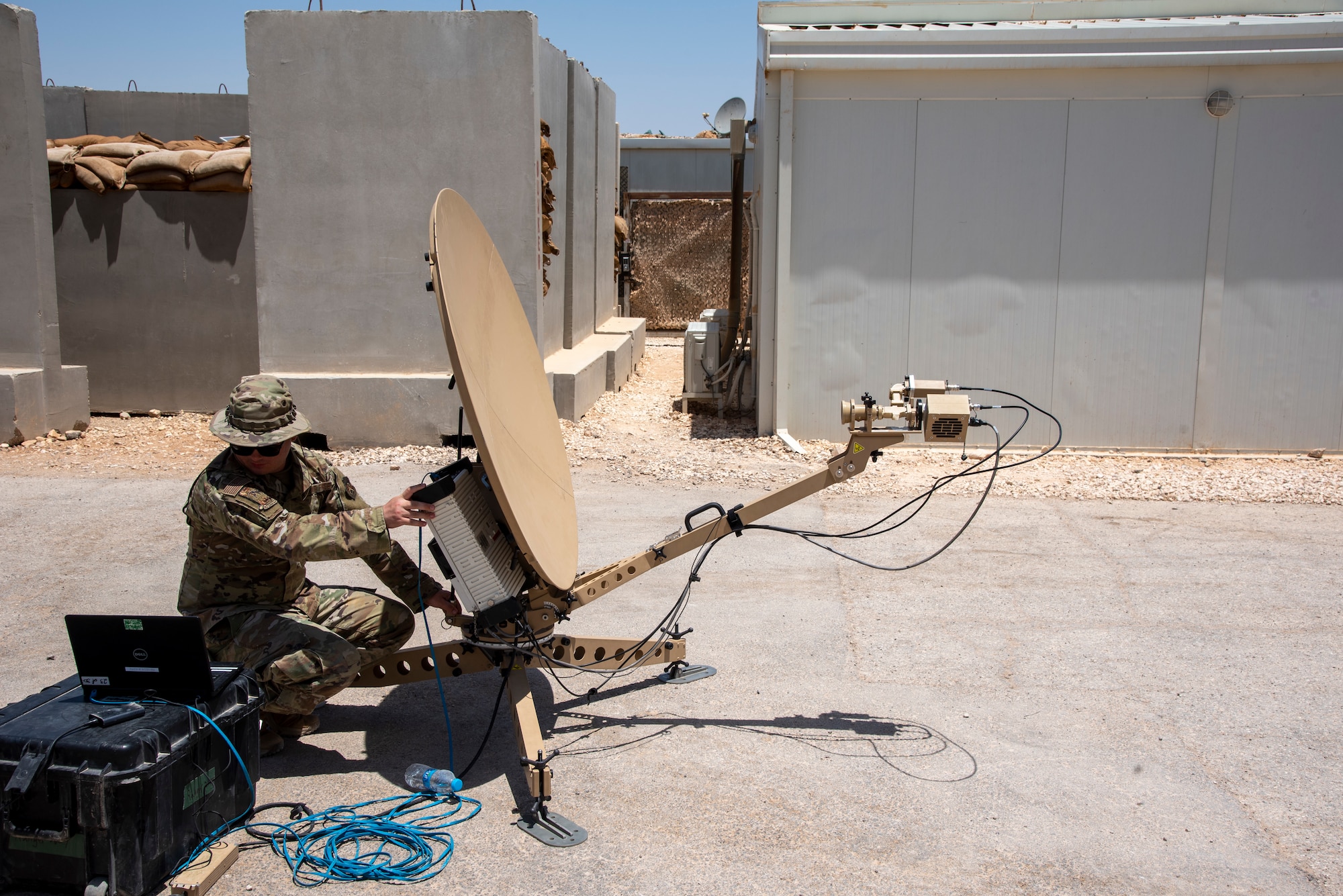 Airman 1st Class Nathan Ammons operates a Communications Fly Away Kit at an undisclosed location, July 20, 2022. The CFK enables the 332d Air Expeditionary Squadron to operate in remote locations by establishing secure communications via satellite. (U.S. Air Force photo by: Tech. Sgt. Jim Bentley)