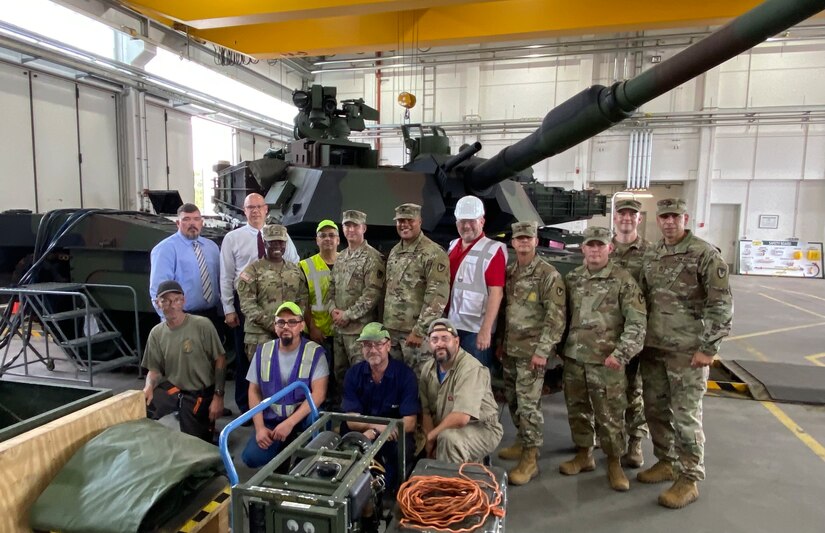 The 405th Army Field Support Brigade command team pose for a group photo with team members from Army Field Support Battalion-Mannheim and Coleman Army Prepositioned Stocks-2 worksite. Army Col. Crystal Hills and Command Sgt. Maj. Terrell Brisentine conducted an APS-2 site visit to Coleman and received an operations briefing from AFSBn-Mannheim Aug. 5 to gain a better understanding of the battalion’s current missions and future transition to APS-2 support operations in Poland.