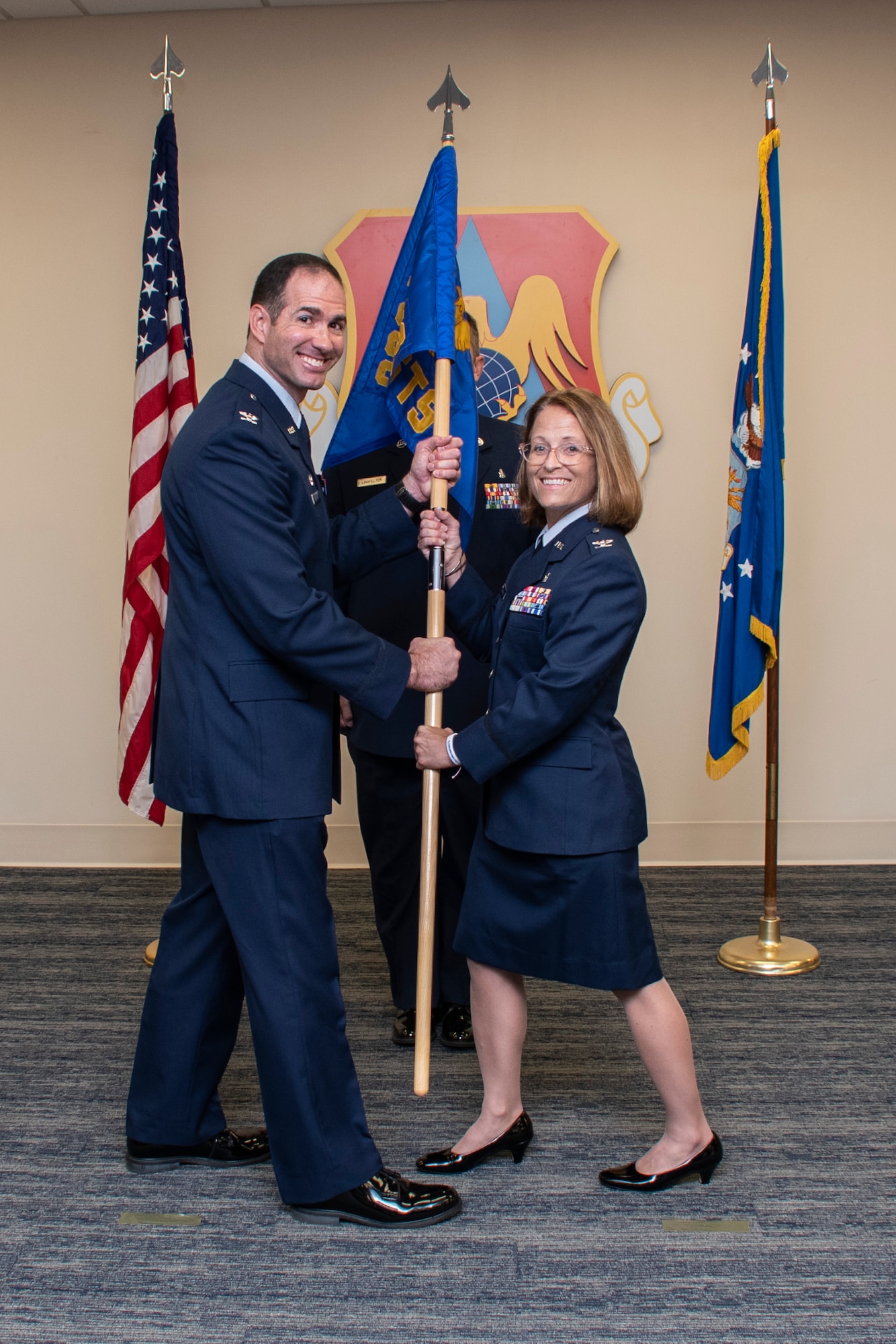 Col. Christopher Spinelli, 932nd Medical Group commander, passes the guidon to Col. Jennifer Brothers, incoming 932nd Aeromedical Staging Squadron during the ASTS assumption of command, Aug 7, 2022, Scott Air Force Base, Ill. (U.S. Air Force photo by SSgt Brooke Spenner)