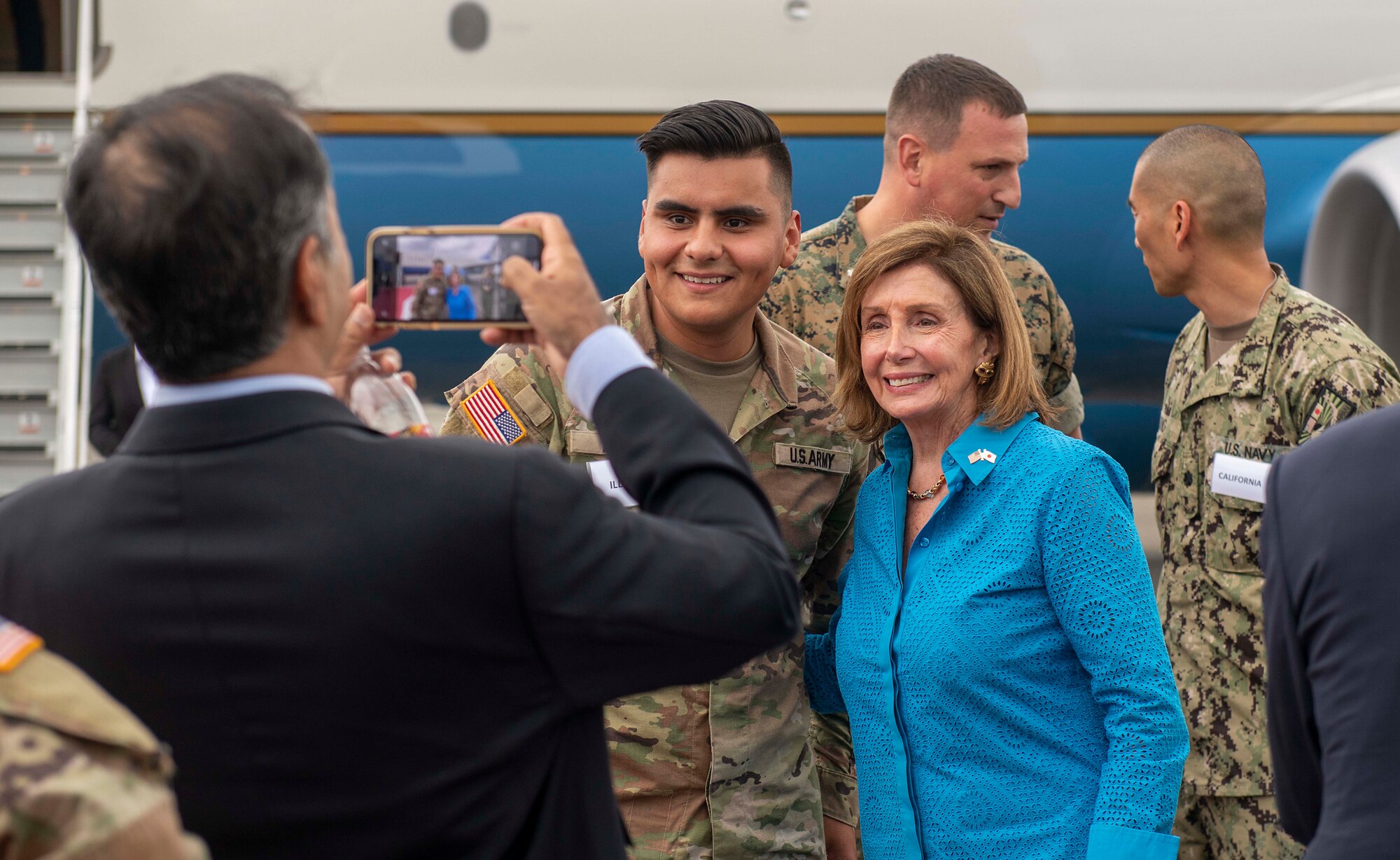 Speaker of the House Nancy Pelosi poses for a photo with service members