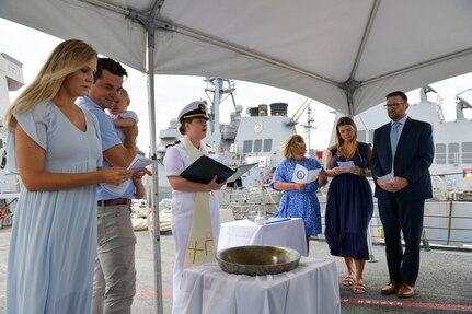 NAVAL STATION NORFOLK (Aug. 5, 2022) Lt. Alisa L. Harl, chaplain aboard the guided-missile destroyer USS Laboon (DDG 58), center, presides over a bell baptism service aboard the ship. Harl baptized Blaze Michael Laboon, the great-great-grandnephew of Laboon’s namesake. (U.S. Navy photo by Mass Communication Specialist 1st Class Jacob Milham)