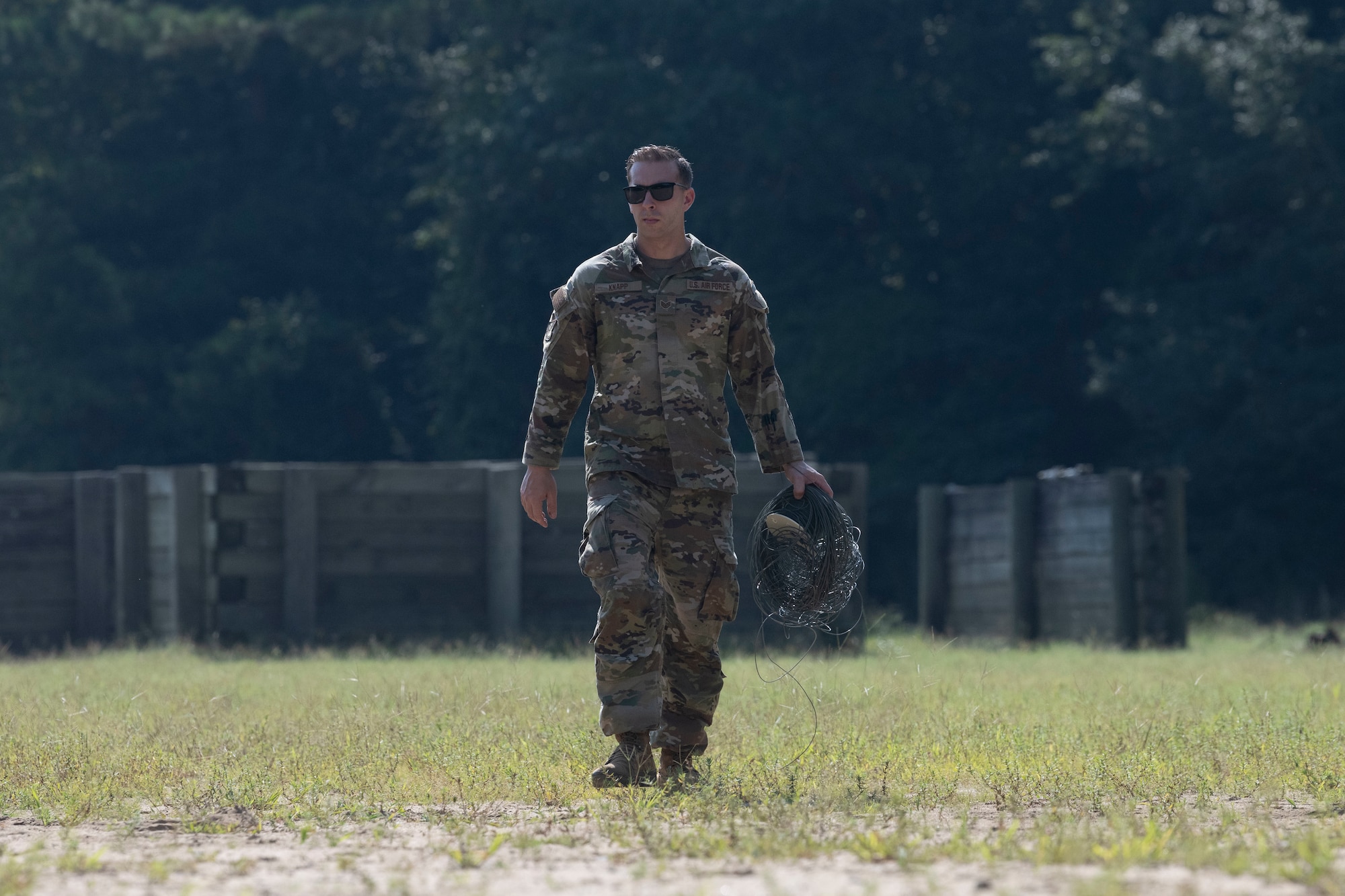 Staff Sgt. David Knapp, Air Force Reserve Command Explosive Ordnance Disposal cross-trainee, carries a used detonation cable after a detonation at Seymour Johnson Air Force Base, North Carolina, Aug. 4, 2022. Knapp is conducting on-the-job training with the 4th Civil Engineer Squadron’s EOD flight prior to attending EOD technical training. (U.S. Air Force photo by Senior Airman Kevin Holloway)