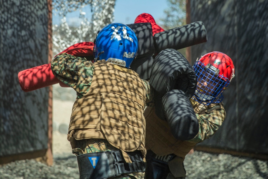 Two Marine Corps recruits compete in a pugil sticks match.