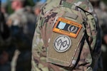 A U.S. Army Soldier assigned to Task Force Orion, 27th Infantry Brigade Combat Team, New York Army National Guard, wears the Combat Training Center-Yavoriv Advisor patch above the 27th IBCT patch during the Joint Multinational Training Group-Ukraine Transfer of Authority ceremony in Grafenwoehr, Germany, August 8, 2022.